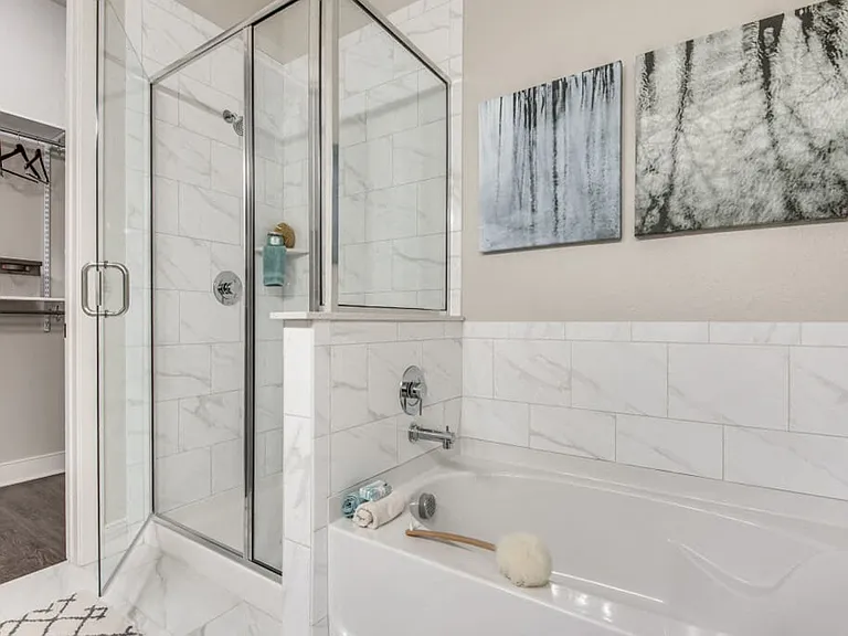 The master bathroom includes a separate tub and shower with tile surround and dual sink vanities.