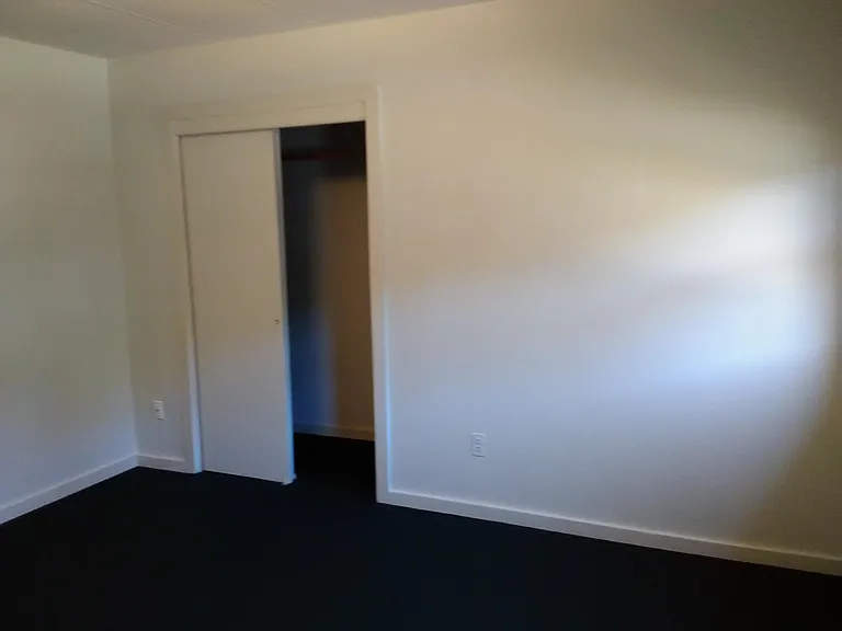 Large bedroom closet with shelves and a light.