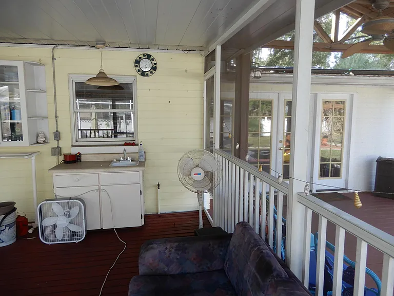 Large wood decked screened porch and entrance to and from pool planned bathroom.