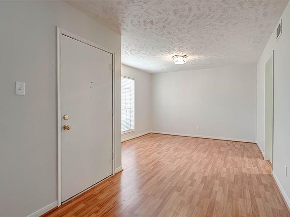 The entry is flanked by traditional formal living and dining areas updated with engineered wood flooring. this would be the dining area . . .