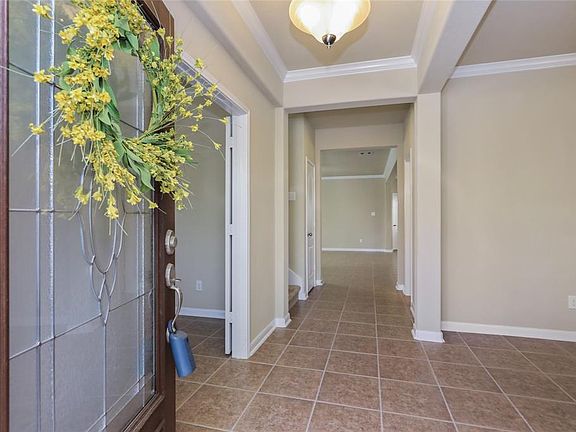 ENTRY HALL: The wide entry hall features a tray ceiling with crown molding, continuing the special architectural details inside.