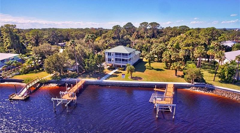 Two lots (home sits on ONE & the other lot  to R of home with lush tropical landscaping  - both lots each with newer dock / lift