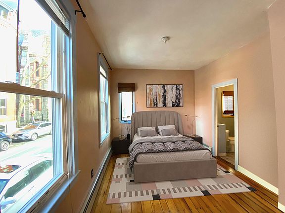 Virtually staged bedroom with bathroom to the right and Warren street to the left