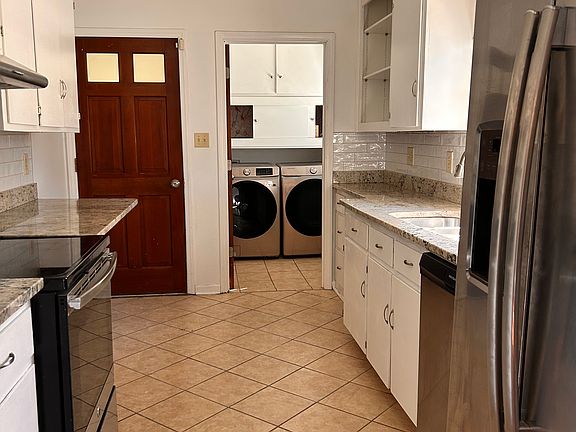 Kitchen with new dishwasher extra large refrigerator, laundry with large machines and loads of storage