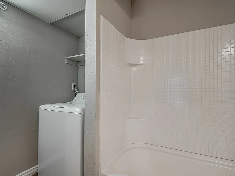 Experience the convenience of a modern bathroom with an in-unit laundry setup.