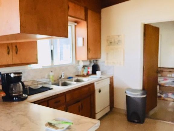 The kitchen has a disposer, refrigerator, built-in stove top, oven, and dishwasher. The laundry room is off the kitchen.