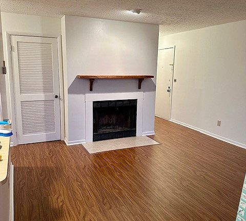 Door to the left of the fireplace is the laundry area that fits a full-size washer/dryer. There is a coin-operated washer/dryer on the third floor of every building. Door to the right is the entry to the unit.