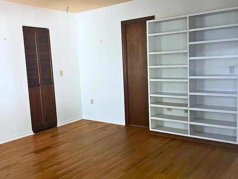 Primary bedroom includes built-in shelves, walk-in closet and leads to bathroom