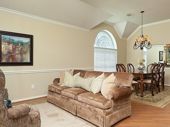 The living room has crown moulding, chair rail and a high ceiling.