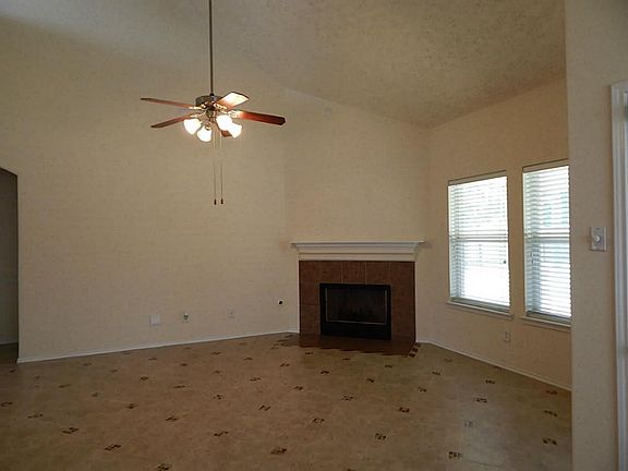 FAMILY ROOM WITH CORNER FIREPLACE, WALL OF WINDOWS AND TILE FLOORING