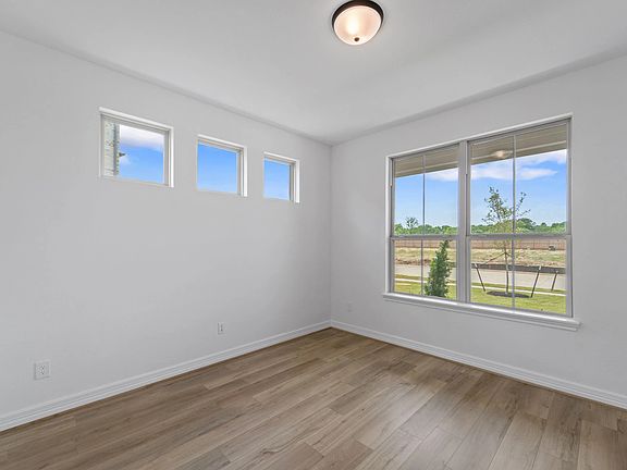The home office features French doors, beautiful floors, large windows that give a fresh feel, this