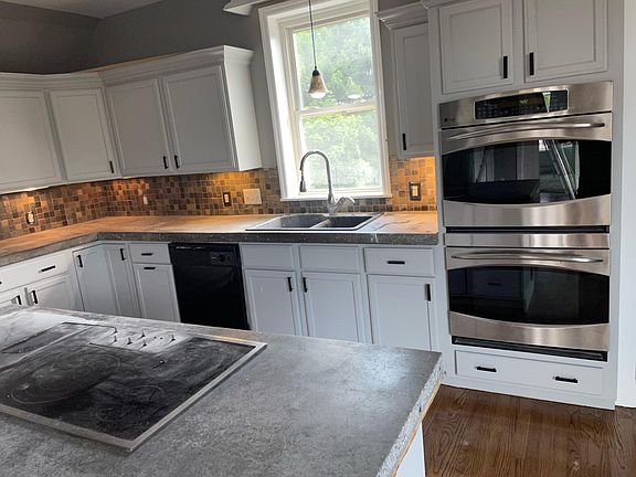 Chef's kitchen with double oven, and stove top in island.