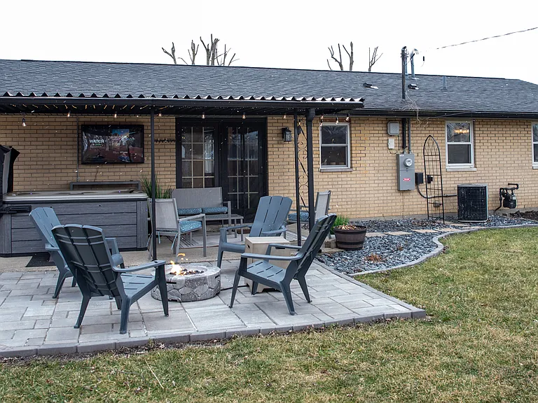 Your private backyard oasis, featuring a hot tub, stone patio, and plenty of space to relax.
