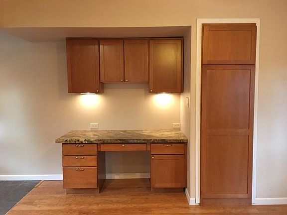 Built-in desk with granite top, next to dining area, and built-in coat closet