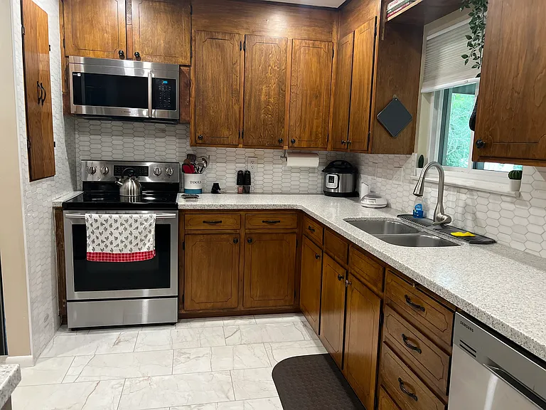 Well-equipped kitchen with modern appliances, full cookware, and a spacious U-shaped layout designed for easy meal prep during extended stays.