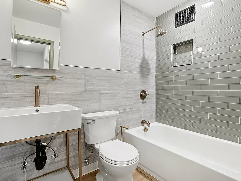 Modern bathroom with elegant gray tiles, sleek fixtures, and a minimalist vanity for a luxurious feel.