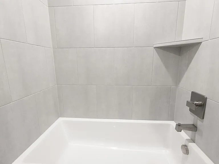 Guest bath with fully tiled cast iron tub surround