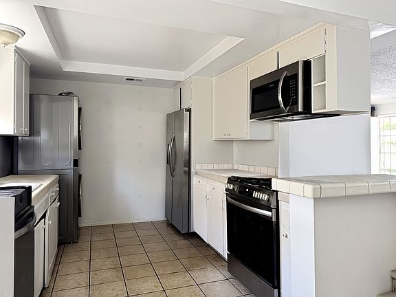 Kitchen with new refrigerator, built-in microwave, and range/oven