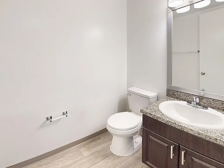 Modern bathroom with elegant granite countertop and sleek white fixtures, perfect for a contemporary apartment.