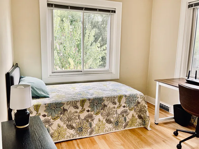 View of the second-floor bedroom from the entrance to the room. The room has a large, deep closet. Windows look onto the side of the house and the backyard.