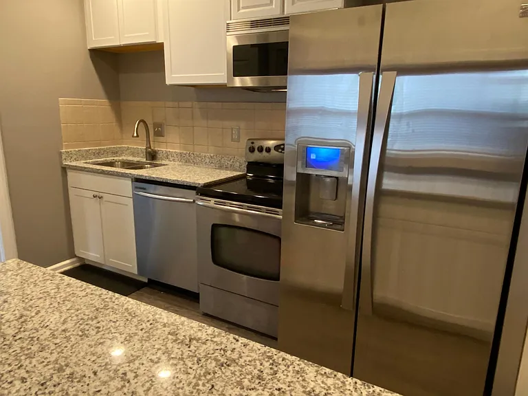 Newly renovated kitchen with high granite island, new cabinets, new floor and new sink, faucet and disposal.
