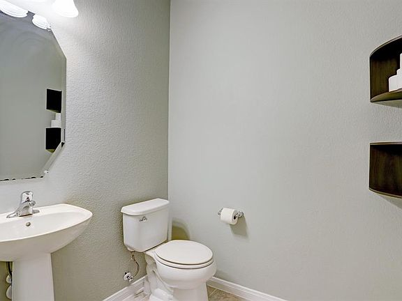 There is a spacious 1/2 bath on the first floor with pedestal sink just past the study.