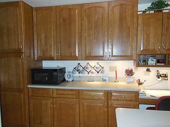 This wall of cabinets includes a fantastic pantry and a small desk area.