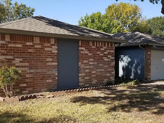 Another view from the front of the house, recently updated with beautiful greenery underneath a sprawling oak tree, providing immense shade.