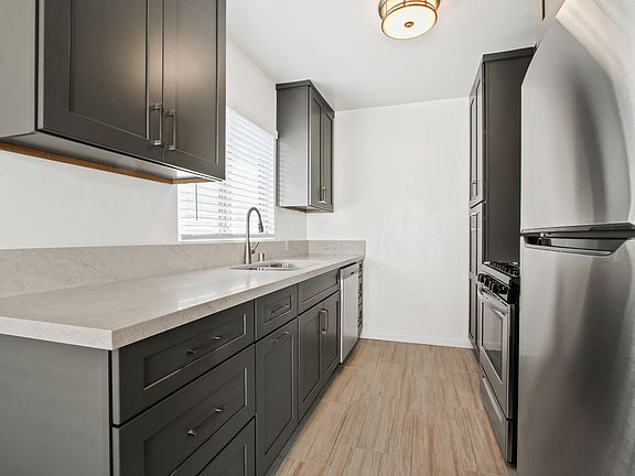 Kitchen with stainless steel appliances, including a range, microwave, refrigerator, and dishwasher.