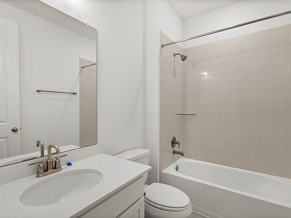 The third bath features tile flooring, white cabinetry and light countertops and a shower tub combo.