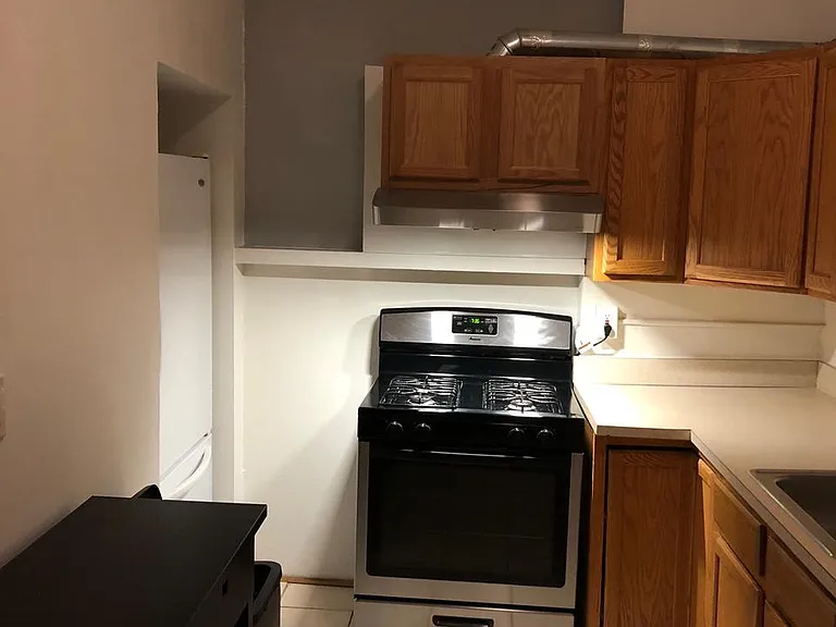 One view of kitchen showing gas stove and refrigerator.