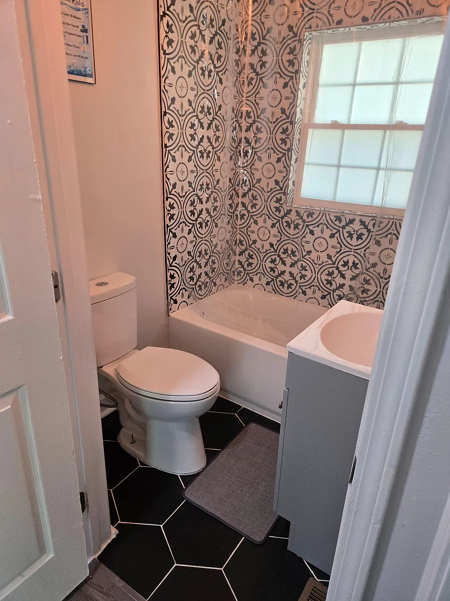 Photo 2 of 9 - Washington Rd - McDonough, GA Compact full bath with a tub/shower combo, patterned tile surround, and a window for ventilation and natural light. - Washington Rd
