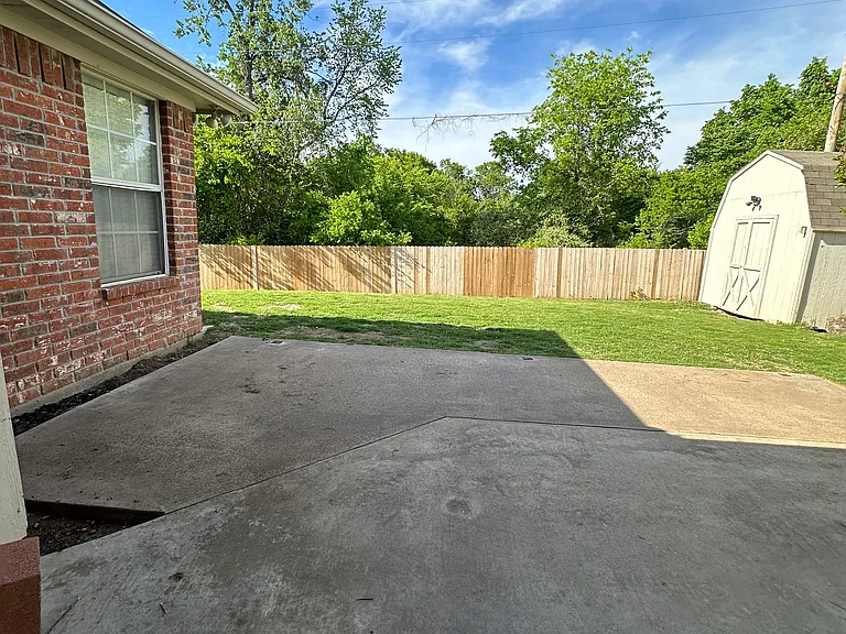 Fully fenced backyard with shed