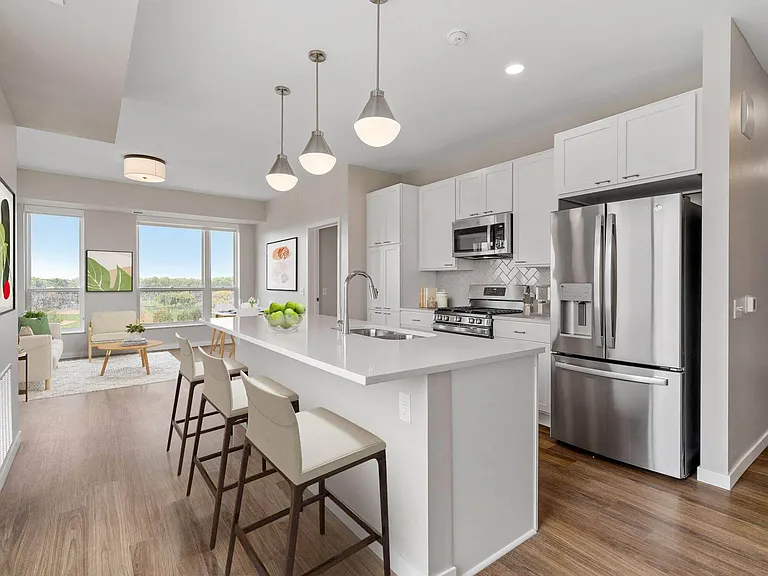 Modern kitchen with stainless steel appliances and counter dining at The Hallon Luxury Apartments in Hopkins MN