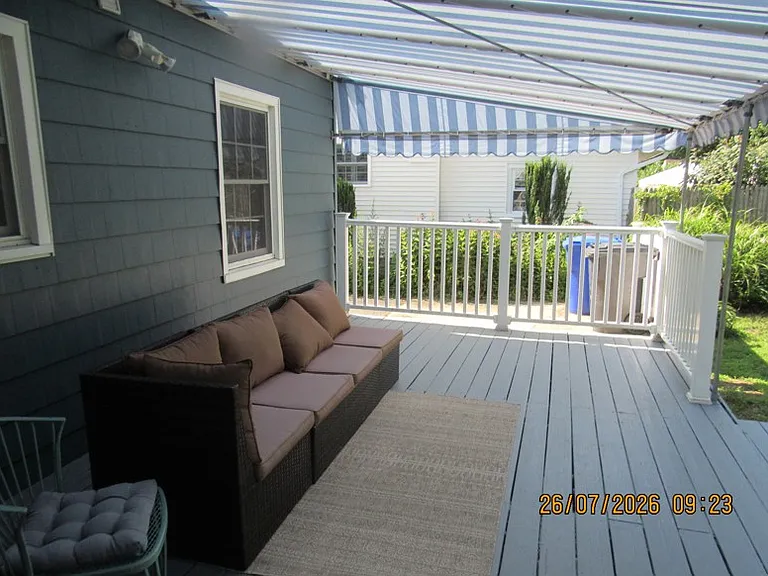 covered rear deck off the den/formal dining room overlooking the large rear yard