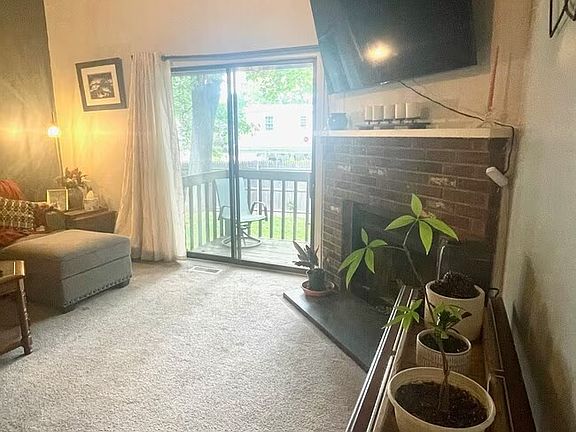Alternative View: Sunken living room with fireplace and sliding glass doors leading to a private deck.