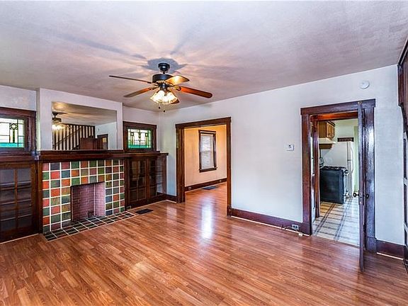 The 18x13 Living room features a gas fireplace with built in glass door book shelves and 2 original stain glass window accompani