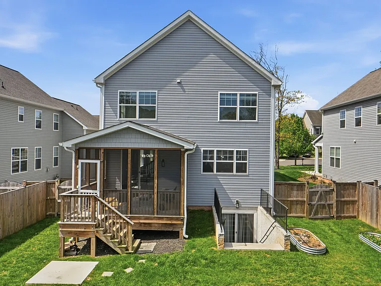 Beautiful backyard with large screened in porch, planter boxes, a grill pad, and a fire pit, ready to host your next family gathering!