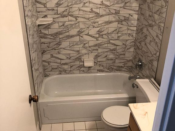 Updated shower tile, hardware and bathtub.