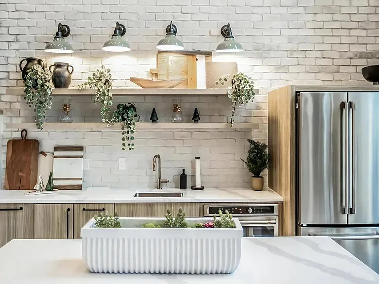 Clubhouse Kitchen with Open Shelving, Brick Accent Wall & Stainless Steel Appliances