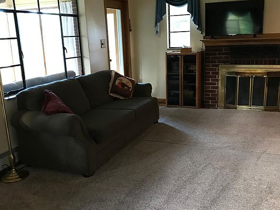 East view of living room. Windows on the left of photo open to a three seasons room with windows in all directions.