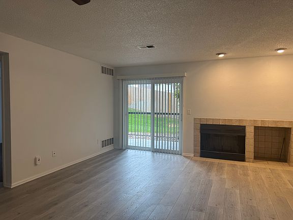 Open concept living, dining and kitchen areas with sliding door to the patio and cozy wood burning fireplace--all new planking
