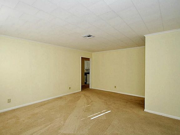 Looking from the living room toward the hallway and remainder of living areas.