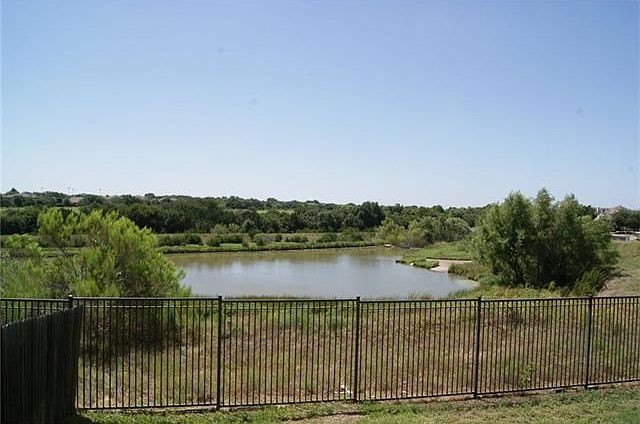 View of pond behind and wrought iron fence.