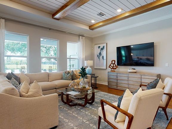 The impressive family room features a coffered ceiling that complements the modern space, which also