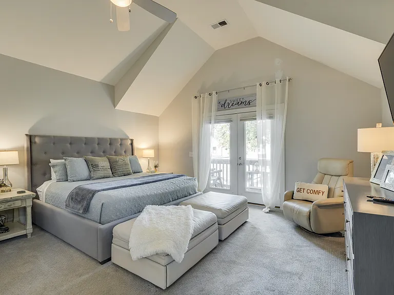 Spacious primary suite featuring a plush pillow-top California King bed, two twin ottoman sleepers for added flexibility, a private walkout balcony, and plenty of room to relax, work, and feel at home during extended stays.