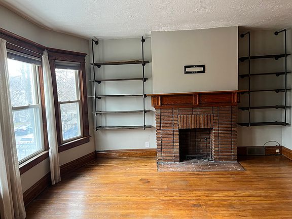 Family room with built in pipe bookshelves and decorative fireplace.