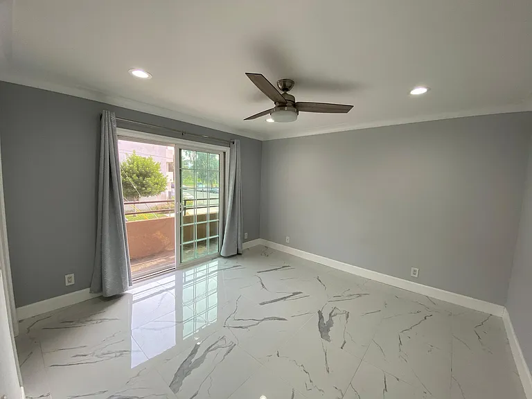 Bedroom With Balcony Showing Park & Hunter Fan.