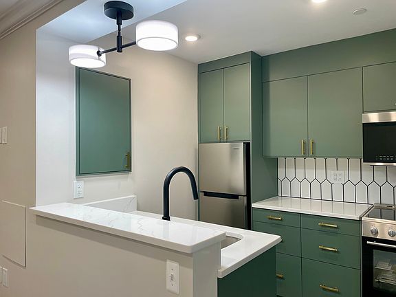 New kitchen with quartz countertops, tile backsplash and plenty of storage.