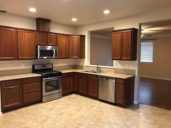 Kitchen with stainless appliances, tile floors, and granite counters